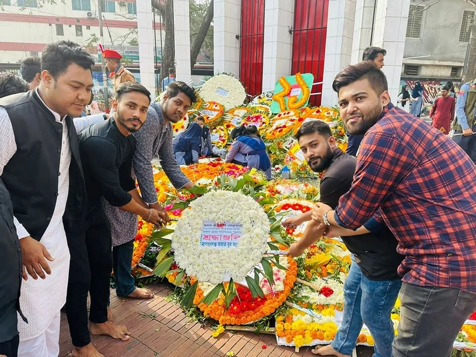 People laying a floral wreath
